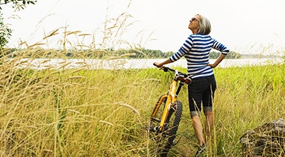 Oudere vrouw met fiets buiten